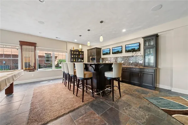 a open kitchen with stainless steel appliances granite countertop a table and chairs in it