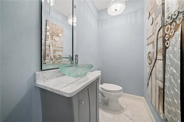 a bathroom with a granite countertop sink a toilet and a mirror
