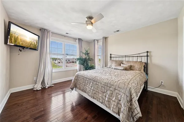 a bedroom with a bed and a flat tv screen on dresser