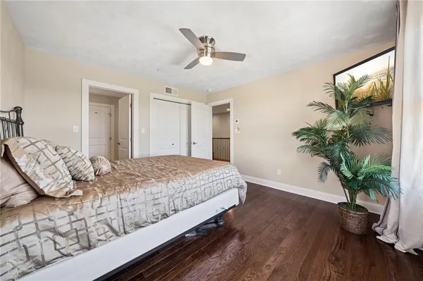 a bedroom with a large bed and a potted plant