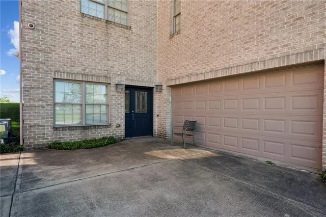 a view of a backyard with brick wall and potted plants