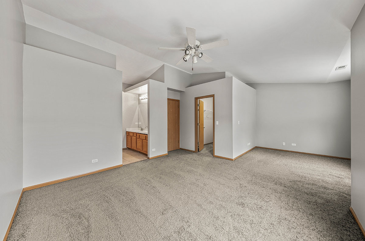 824 County Line Road Aurora, IL 60502 - Photo 11 of 18 an empty room with chandelier fan and windows