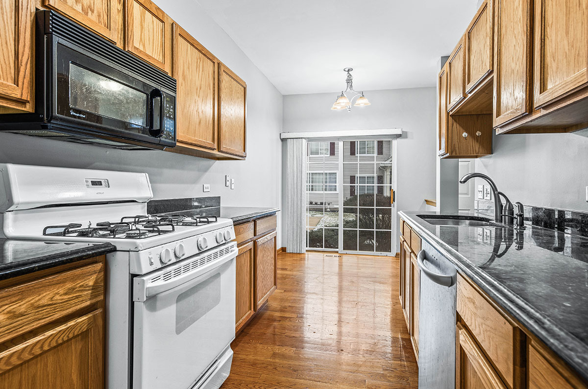 824 County Line Road Aurora, IL 60502 - Photo 8 of 18 a kitchen with stainless steel appliances granite countertop a stove top oven a sink dishwasher and white cabinets with wooden floor