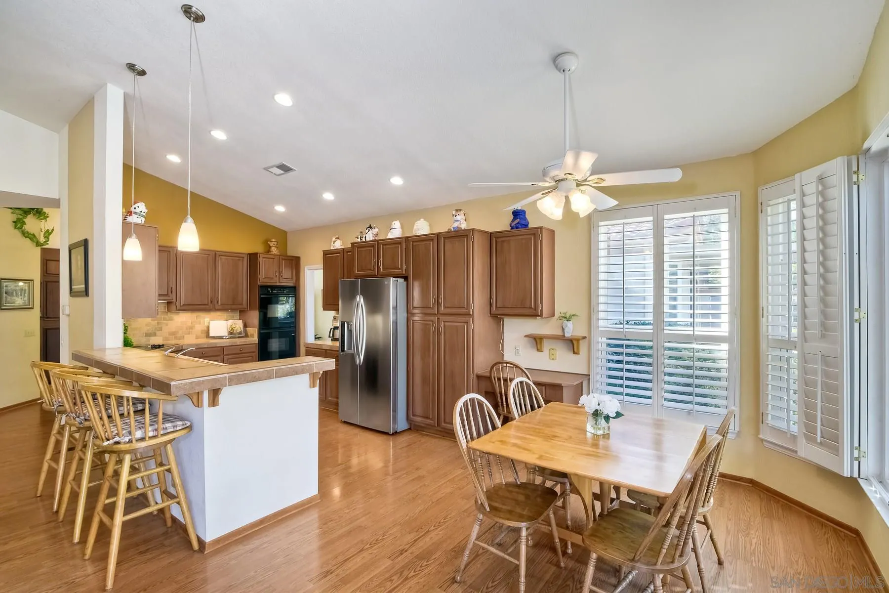 13892 Oakstand Road Poway, CA 92064 - Photo 6 of 27 a kitchen with stainless steel appliances kitchen island granite countertop a refrigerator a stove a kitchen island with a dining table and chairs