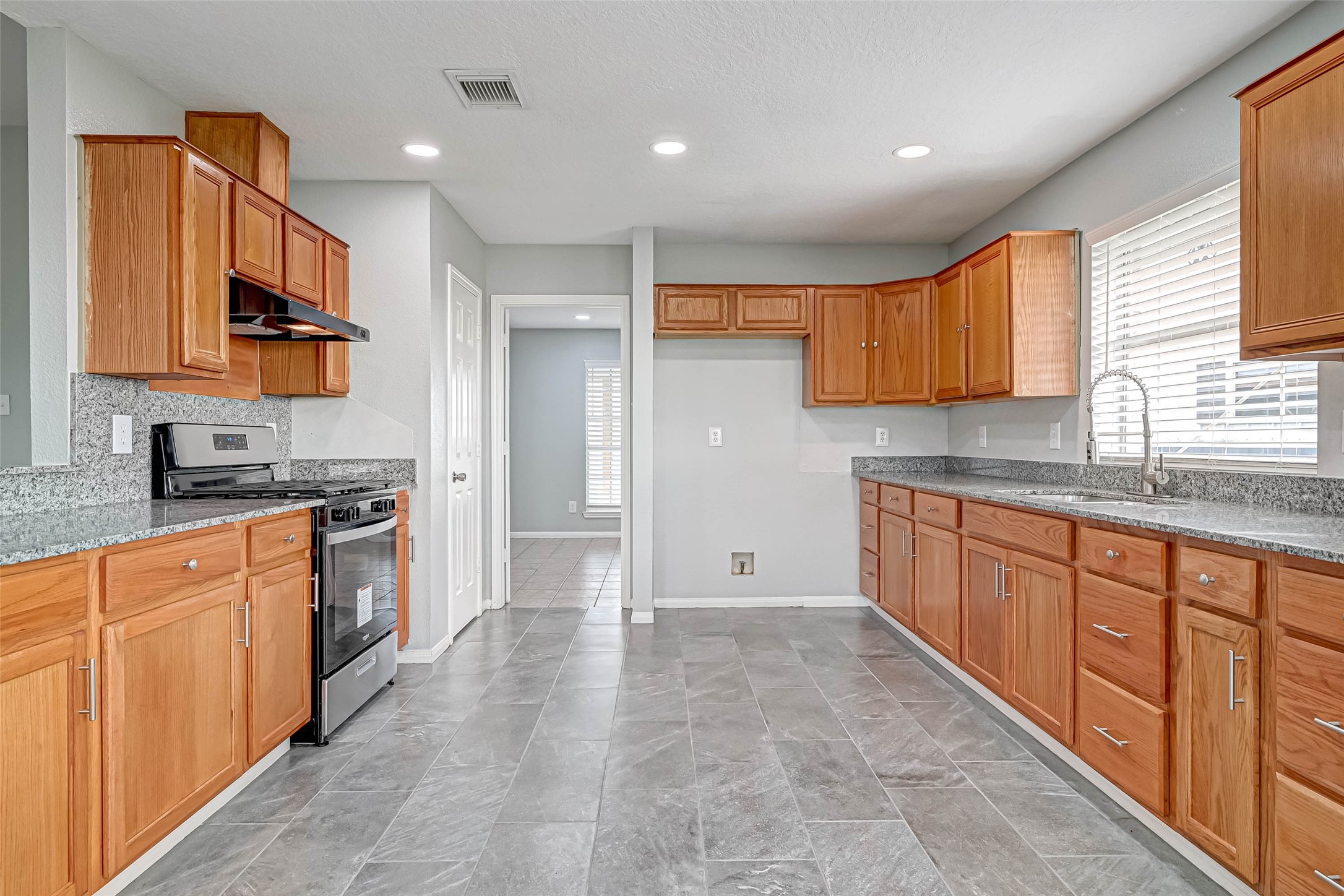 7520 Vincik Ehlert Road Rosenberg, TX 77471 - Photo 19 of 46 a large kitchen with stainless steel appliances granite countertop a stove a sink and a refrigerator