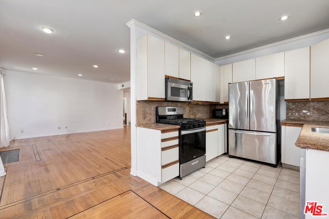 1169 Wellesley Avenue, Unit 101 Los Angeles, CA 90049 - Photo 15 of 26 a kitchen with stainless steel appliances granite countertop a refrigerator sink and stove