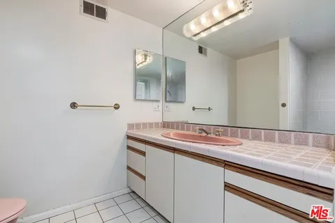 a bathroom with a sink a toilet and a mirror
