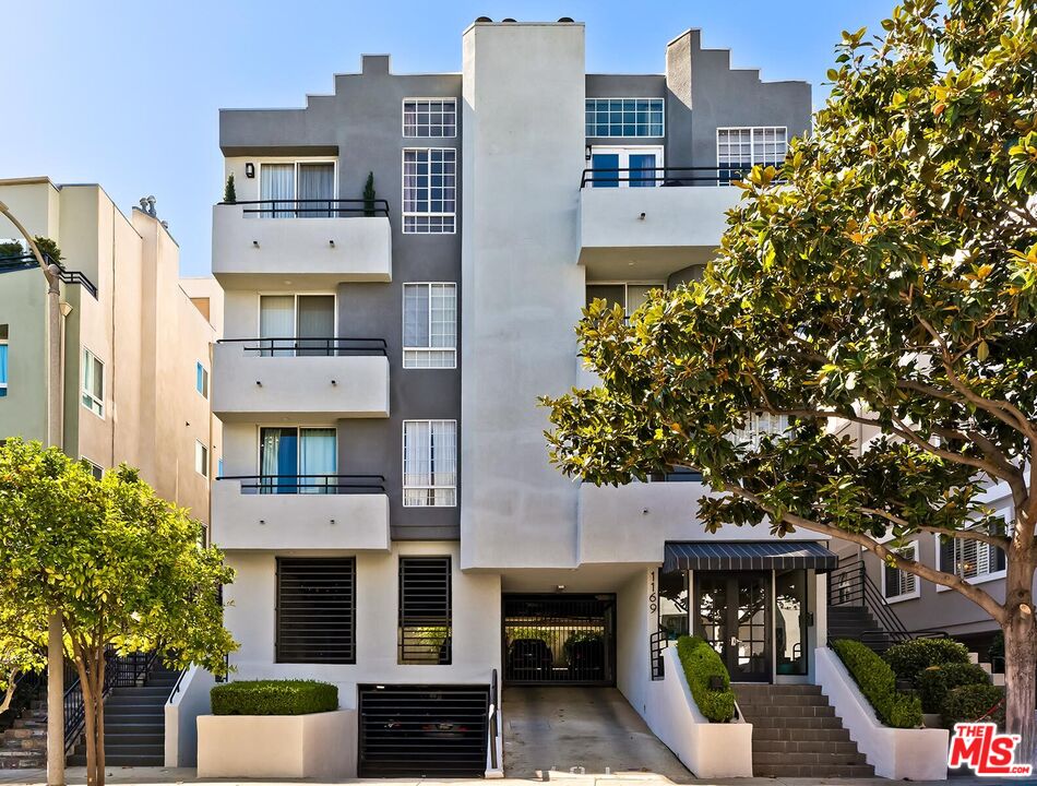 1169 Wellesley Avenue, Unit 101 Los Angeles, CA 90049 - Photo 2 of 26 a front view of a building with glass windows and plants