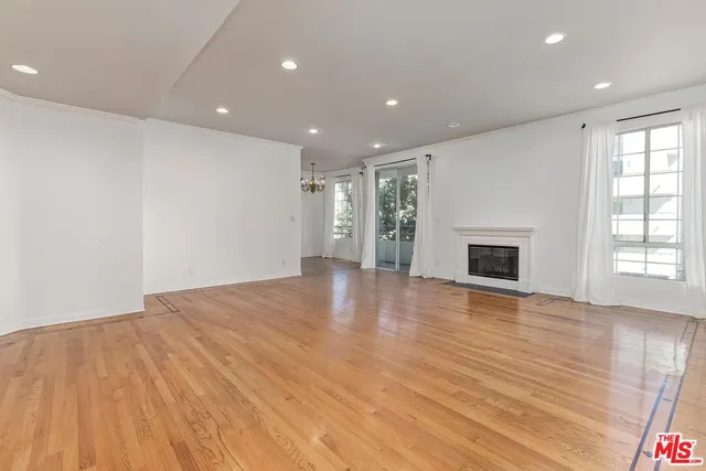 an empty room with wooden floor and fireplace