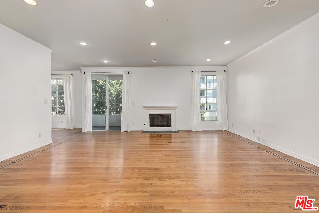 1169 Wellesley Avenue, Unit 101 Los Angeles, CA 90049 - Photo 5 of 26 wooden floor in an empty room with a window