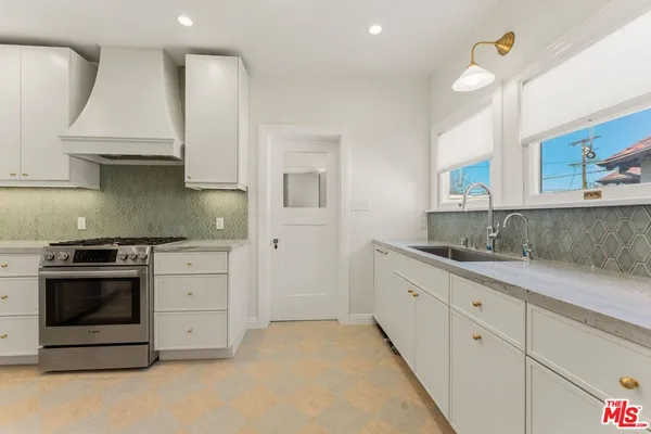 a kitchen with granite countertop white cabinets and white appliances