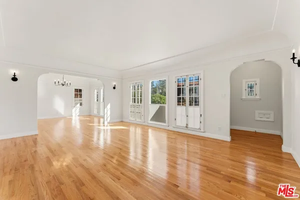 a view of empty room with wooden floor and floor to ceiling window