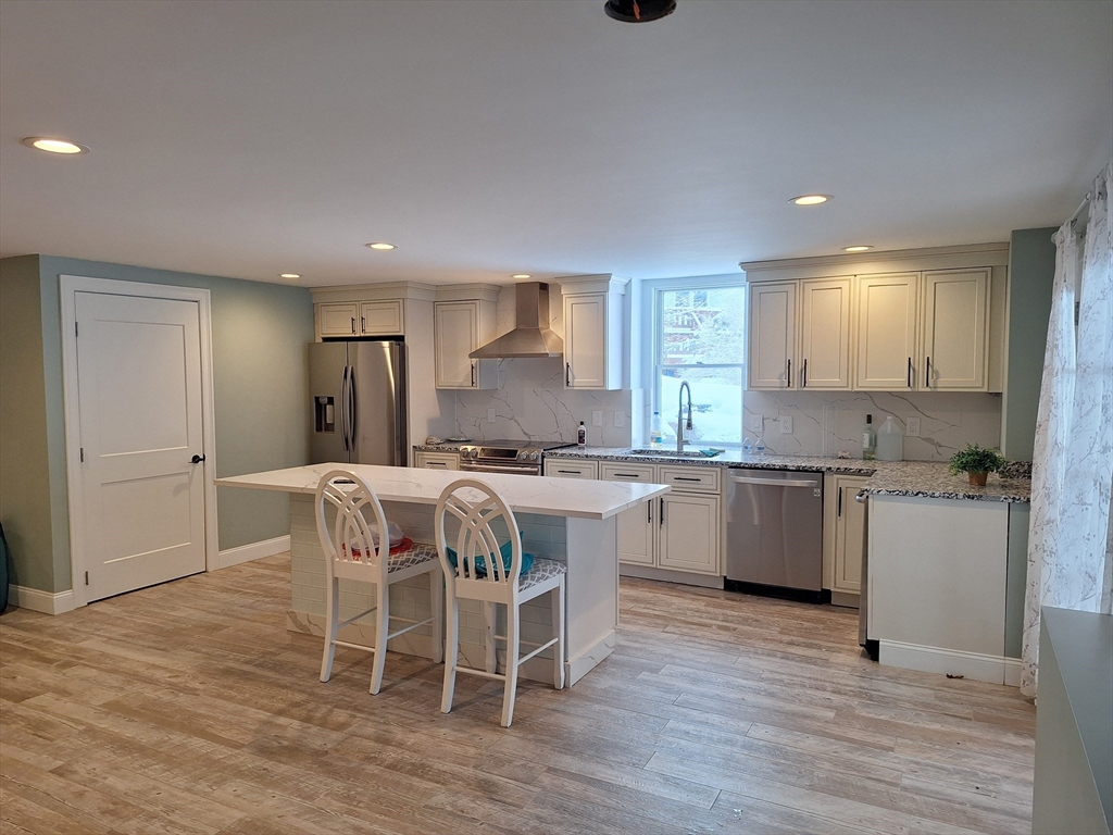48 Gee Avenue, Unit B Gloucester, MA 01930 - Photo 8 of 12 a kitchen with a sink cabinets and wooden floor