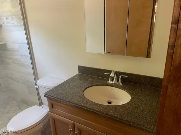 a bathroom with a granite countertop sink and a mirror