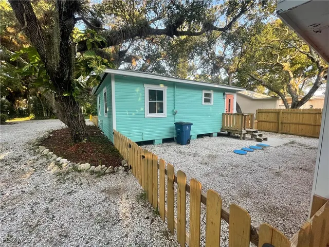 a view of a house with a yard and large tree