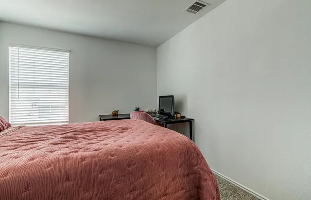 a bed sitting in a bedroom next to a window