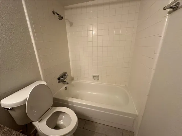a white toilet sitting next to a bath tub