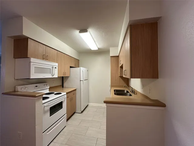 a kitchen with stainless steel appliances a stove sink and a refrigerator