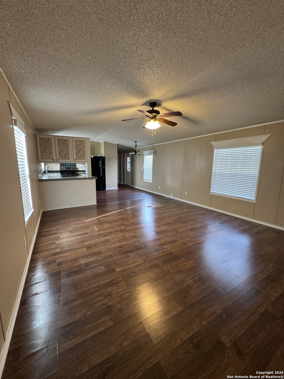 110 Deer Park Road, Unit B La Vernia, TX 78121 - Photo 6 of 12 an empty room with wooden floor and chandelier