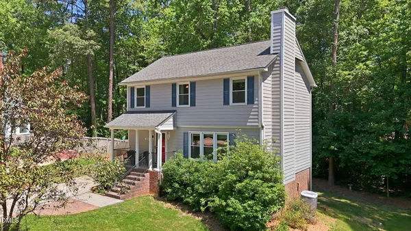 a aerial view of a house next to a yard with plants and trees