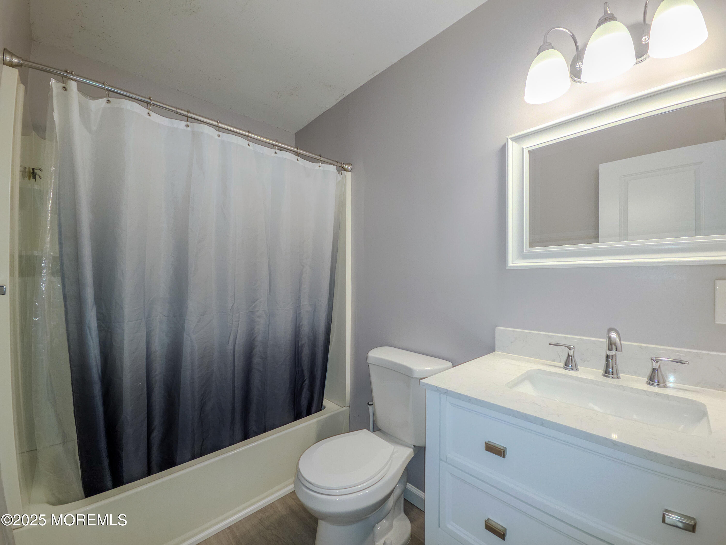 12 Creek Road Brick, NJ 08724 - Photo 7 of 7 a bathroom with a sink a toilet a mirror and shower curtain