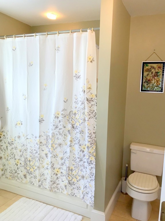 343 Quarry Street, Unit 2 Quincy, MA 02169 - Photo 22 of 30 a white toilet sitting next to a shower curtain