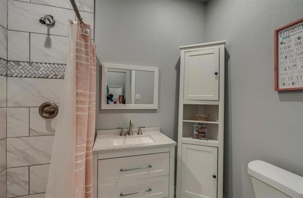 997 Ovilla Road Waxahachie, TX 75167 - Photo 22 of 32 White shaker vanity with a rectangular undermount sink and a speckled countertop