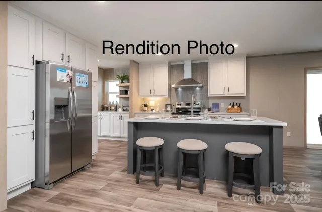 a kitchen with stainless steel appliances a sink cabinets and wooden floor