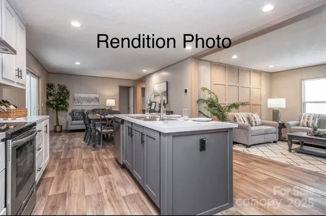 a view of a kitchen with kitchen island stainless steel appliances a sink table and chairs