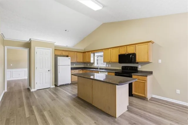 a kitchen with stainless steel appliances granite countertop a stove a sink and a refrigerator