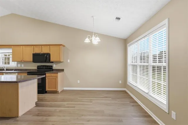 a kitchen with granite countertop a stove and a wooden floor