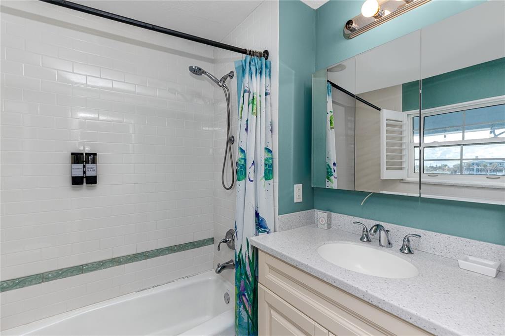 2601 Bay Boulevard Indian Rocks Beach, FL 33785 - Photo 22 of 64 a bathroom with a granite countertop sink mirror and a bathtub