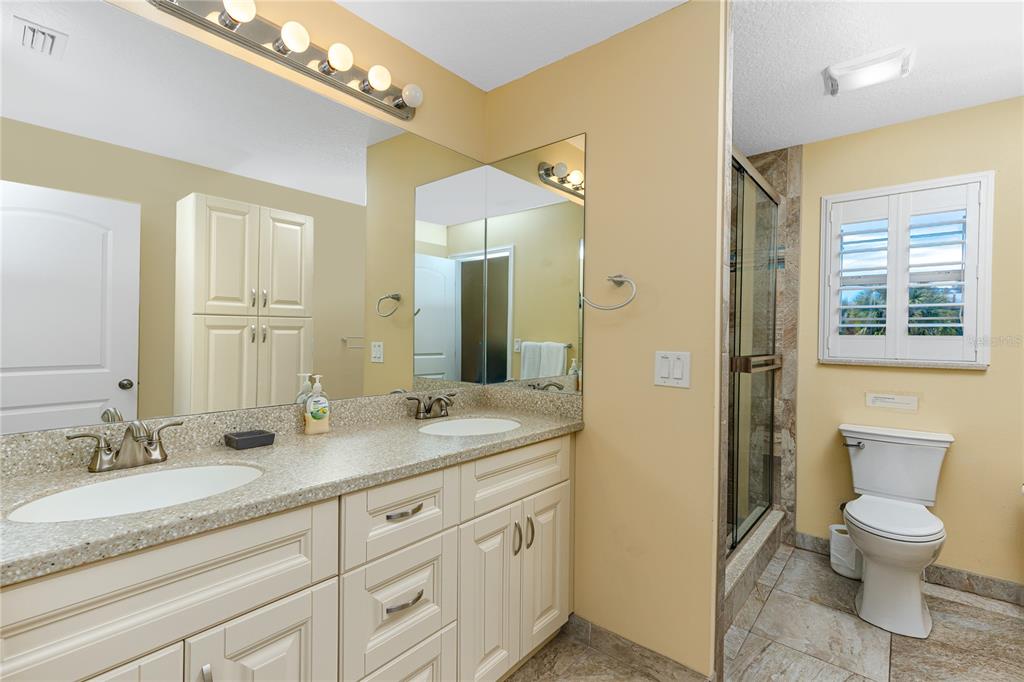 2601 Bay Boulevard Indian Rocks Beach, FL 33785 - Photo 26 of 64 a bathroom with a granite countertop sink a toilet and a large mirror