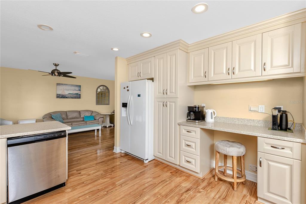 2601 Bay Boulevard Indian Rocks Beach, FL 33785 - Photo 8 of 64 a kitchen with stainless steel appliances granite countertop a refrigerator a stove and white cabinets with wooden floor