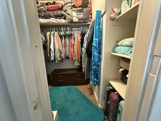 a view of walk in closet with clothes and shoes