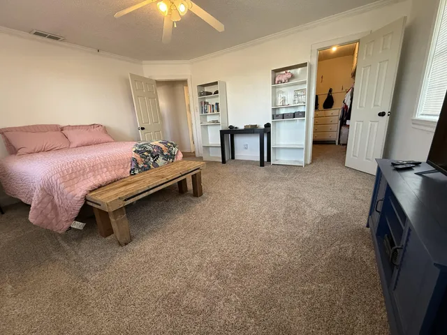 a spacious bedroom with a bed and a chandelier