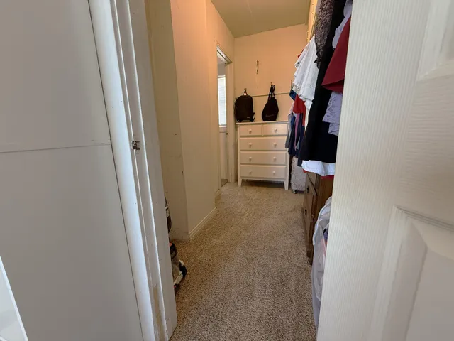 a view of walk in closet with clothes and shoes