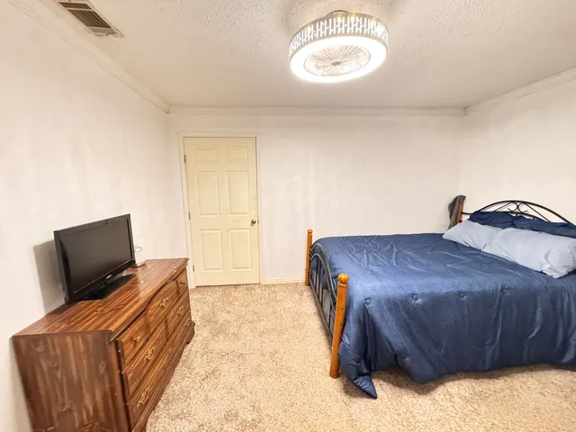 a bedroom with a bed and flat screen tv
