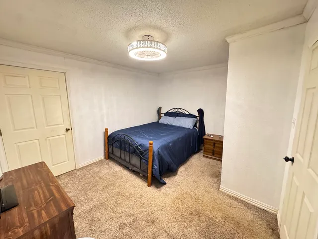 a living room with a bed and a dresser