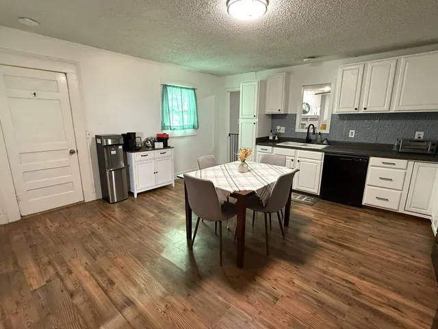 a kitchen with a dining table chairs and white appliances