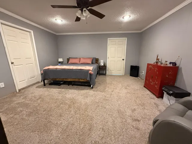 a spacious bedroom with a bed and a window