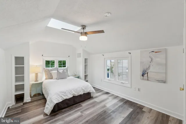a bedroom with a large bed wooden floor and window