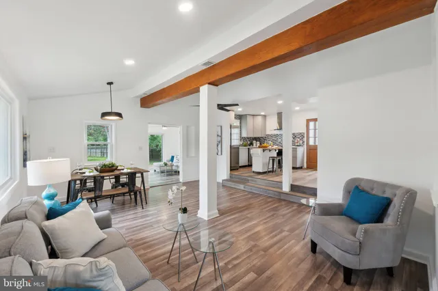 a living room with furniture and a dining table with wooden floor