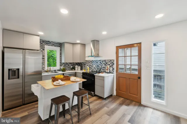 a kitchen with a refrigerator and a stove top oven