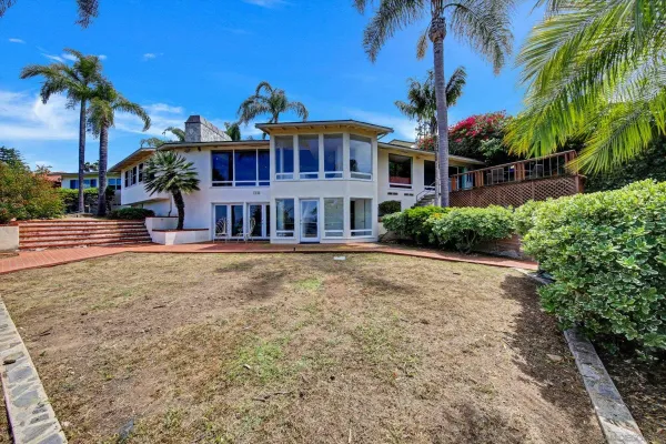 a front view of a house with a garden