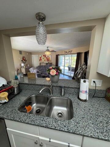 3290 Southeast Aster Lane, Unit D259 Stuart, FL 34994 - Photo 8 of 16 a kitchen counter with a sink and a granite counter top