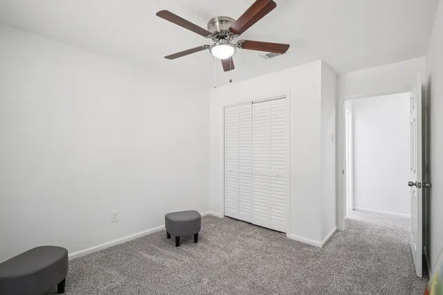 an empty room with a ceiling fan and a walk in closet