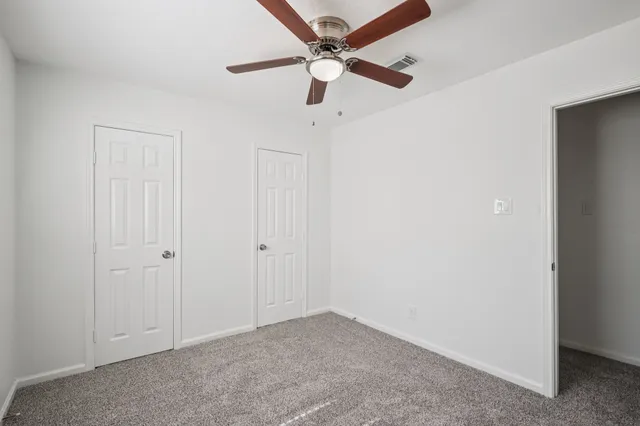 an empty room with a ceiling fan