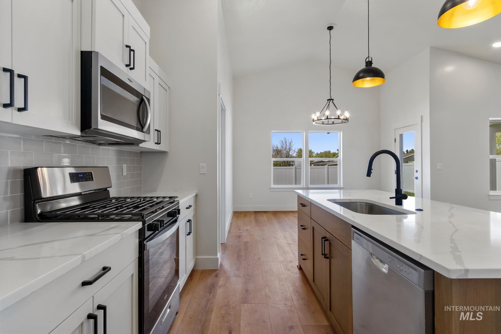 321 North 11th Street Parma, ID 83660 - Photo 19 of 36 Modern kitchen featuring white shaker cabinetry, stainless steel appliances, and a subway tile backsplash