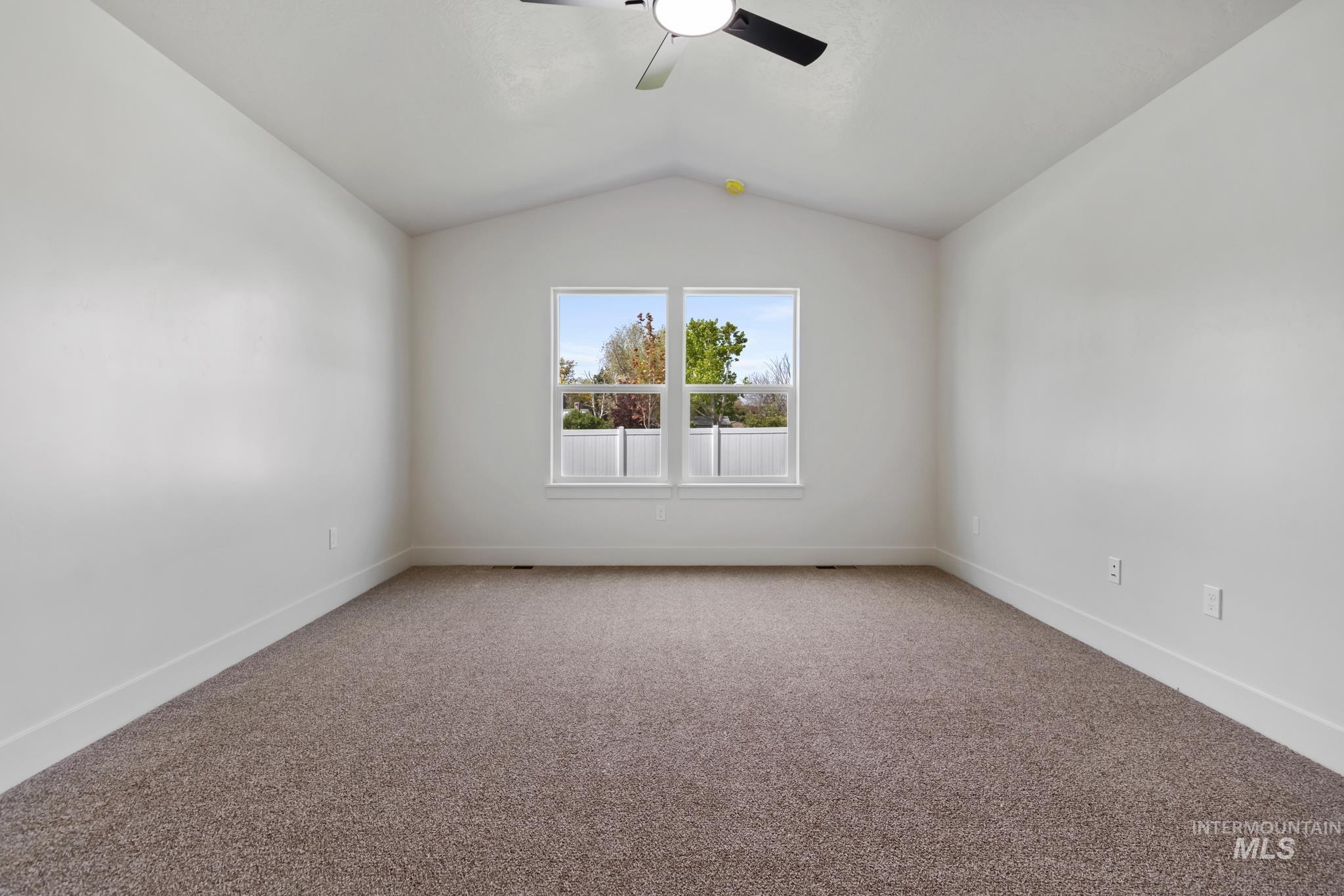 321 North 11th Street Parma, ID 83660 - Photo 23 of 36 Spacious room featuring vaulted ceilings, neutral-toned carpeting, and a double window with white trim